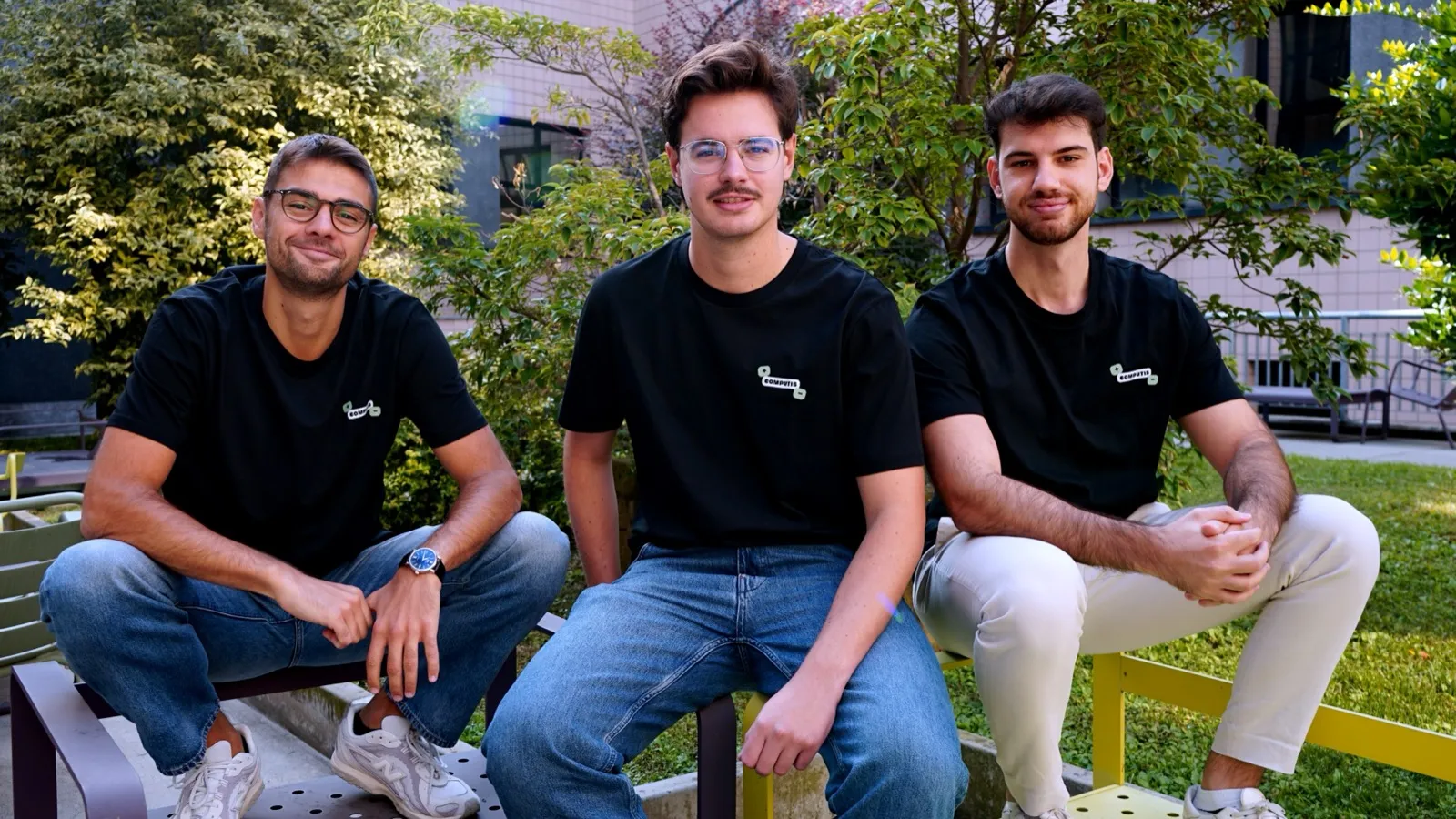 Enrico Nicosia, Riccardo Donatelli e Leonardo Drici seduti in un cortile, con la maglietta nera di Computis